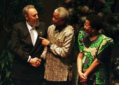 O então presidente sul-africano Nelson Mandela (centro) aperta a mão do seu homólogo cubano, Fidel Castro, na presença da mulher de Mandela, Graça Machel, durante a Cúpula do Movimento de Países Não Alinhados, em Durban.