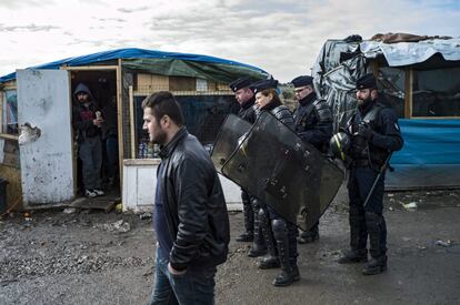 Agentes de la Compañía Republicana de Seguridad (CRS) patrullan por el campamento temporal conocido como 'La Jungla', en las afueras de Calais, Francia.