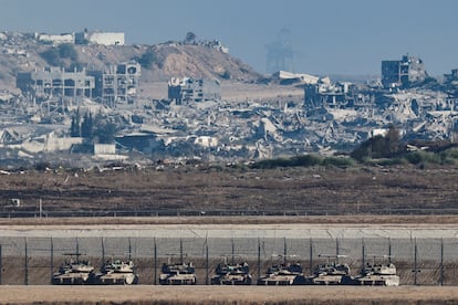 Tanques en el lado israelí de la valla de Gaza, cuya destrucción se observa al fondo.   