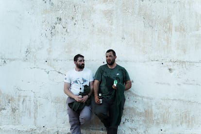 Dos hombres comparten unas cervezas tras finalizar una ceremonia de Semana Santa.