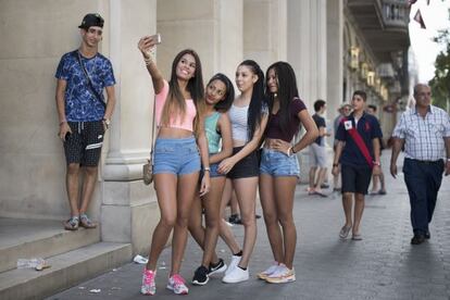 Cuatro jóvenes se fotografían frente a la tienda de Apple de Barcelona.