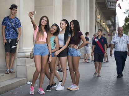 Quatre joves es fotografien davant de la botiga d'Apple de Barcelona.