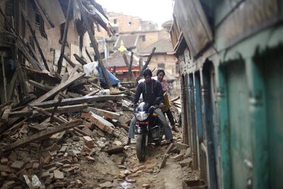 Un hombre conduce una motocicleta entre los restos de varios edificios destrozados en el distrito de Bhaktapur (Nepal), el 27 de abril de 2015.