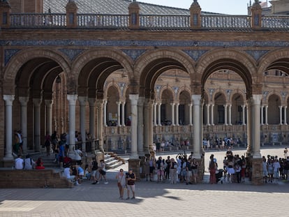 Un gran grupo de turistas protegidos del sol en la sombra en la Plaza de España, este miércoles en Sevilla.