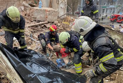 Un grupo de bomberos trabaja en el rescate del cuerpo sin vida de un menor de 10 años tras el ataque ruso a un edificio de viviendas en la ciudad ucrania de Járkov, este viernes. El ataque con misiles también ha causado la muerte de la abuela del niño, además 28 heridos, entre ellos un bebé de 11 meses.