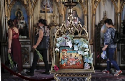 Dinero depositado sobre un ícono religioso, en una iglesia de Costesti (Rumanía).