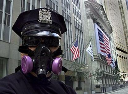 Un policía con una máscara antigas, frente a la Bolsa de Wall Street.