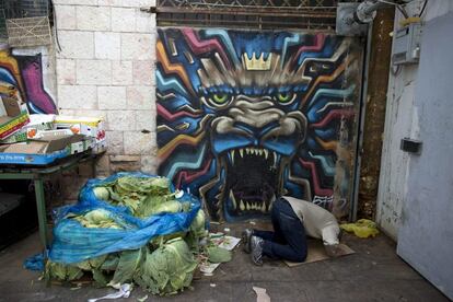 Un musulmán reza junto a un grafiti pintado por el artista callejero Solomon Souza.