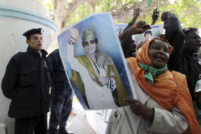 Una mujer muestra el retrato de Gadafi durante una protesta contra los ataques aliados.