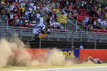 Carmelo Morales rueda por el suelo tras caerse entrando en la recta de meta y la moto vuela hasta caer encima del piloto