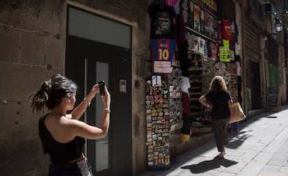 Una mujer hace una foto en una calle de Barcelona.