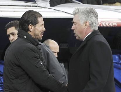 El técnico argentino del Atlético de Madrid Diego Simeone (i), y el entrenador italiano del Real Madrid, Carlo Ancelotti (d), se saludan momentos antes del inicio del partido de ida de las semifinales de la Copa de Rey disputado esta noche en el estadio Santiago Bernabéu. 