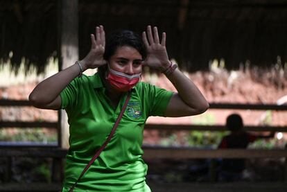 La maestra gesticula en una clase, protegida por una mascarilla.