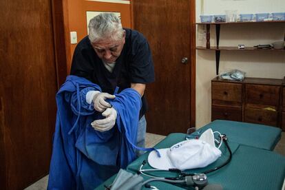El doctor Manuel Lizárraga se prepara antes de salir a dar consultas a domicilio a pacientes de coronavirus.