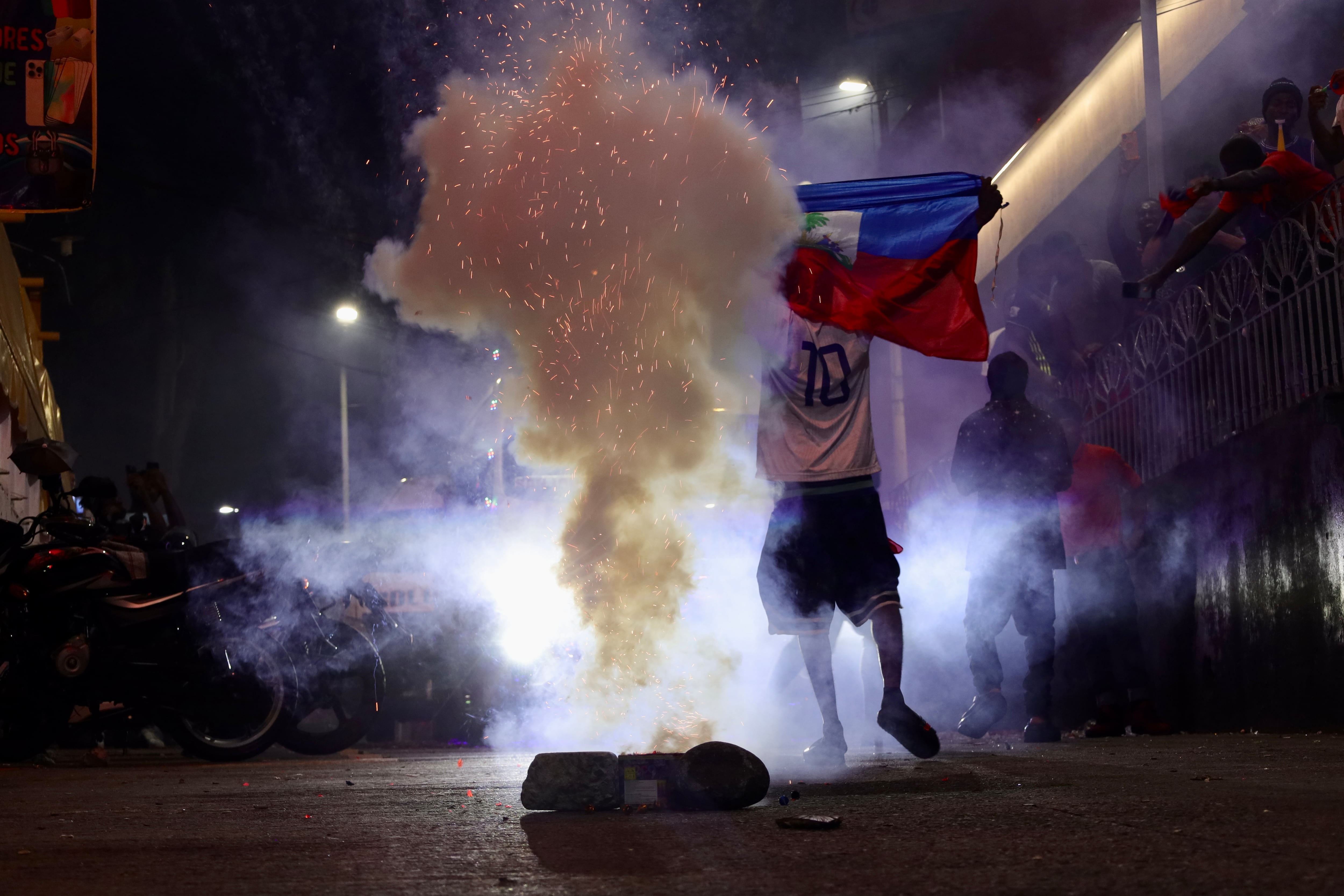Thog celebra con pirotecnia y la bandera de su país la participación de su selección en la Copa del Mundo.