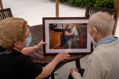 Agustina Cañamero y Pascual Pérez miran, en la residencia donde viven en Barcelona, la fotografía que les tomó Emilio Morenatti en su reencuentro tras 102 días sin verse por la pandemia.