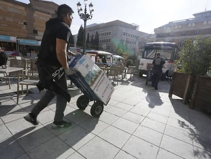 Varios trabajadores transportan mercancía en Madrid.