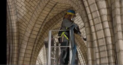 This video grab taken on April 13, 2022, from AFP footage shows a staff member use a vacuum cleaner inside Notre-Dame de Paris, after the blaze that made the spire collapsed and destroyed much of the roof on April 15, 2019. - Three years after the devastating fire, Notre-Dame cathedral in Paris is mostly cleared of a thick layer of soot as an army of craftsmen race to meet a deadline to reopen in time for the 2024 Olympics. (Photo by Colin BERTIER / AFP)