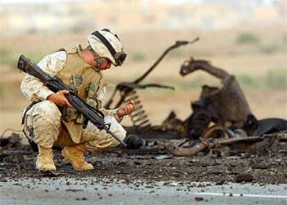 Un soldado estadounidense examina los restos de un convoy tras sufrir una emboscada cerca de Faluya.