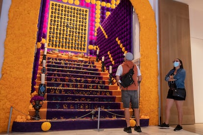 Dos personas frente al Altar de Muertos de 2021, en la Casa de México, en Madrid