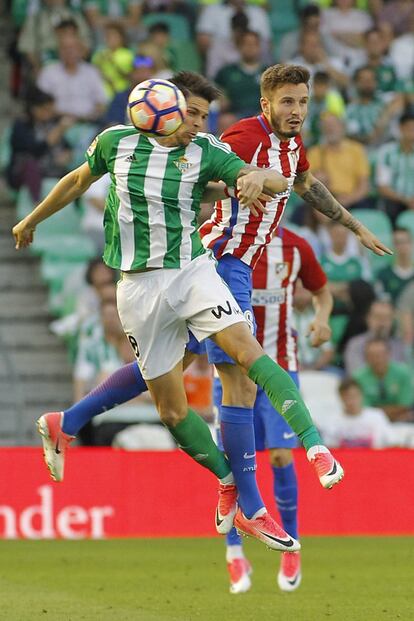 El jugador del Real Betis, Jonas (i) salta a cabeza con el jugador del Atlético de Madrid, Saœl (d).