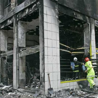 Varios bomberos trabajan en las tareas de desescombro tras el incendio provocado en la ferretería.