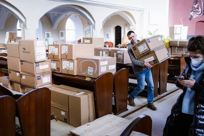 Un voluntario carga en la parroquia de Philippus-Nathanael, en Berlín, cajas de material médico que Oleksii y Thomas van a llevar hasta la frontera de Polonia con Ucrania con un coche y una furgoneta. 