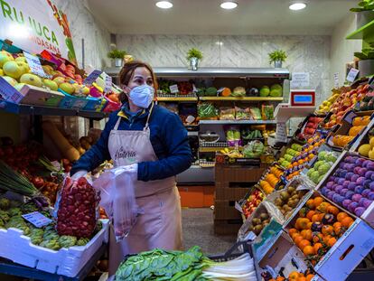 Una vendedora de frutas sirve a una clienta.