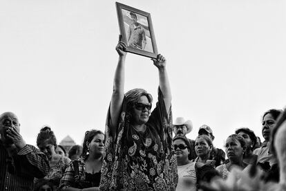Mirna Nereida Medina levanta la fotografía de su hijo, Roberto Corrales, durante su funeral luego de tres años de búsqueda.