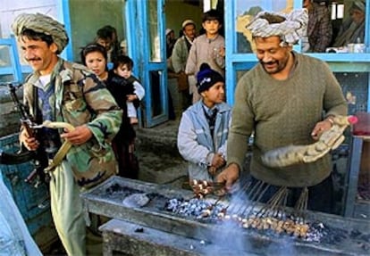 Un afgano prepara pinchos de carne al estilo tradicional ante una casa, en Mazar-i-Sharif.