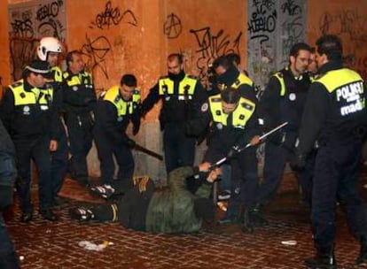 Un grupo de policías municipales rodea a un joven caído en el suelo, al que intenta quitar una muleta, en la confluencia de la calle de la Palma y Corredera Alta de San Pablo.