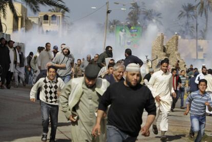 Manifestantes anti-Gadafi huyen de los gases lacrimógenos lanzados por la policía para dispersarles en Tajura, un barrio de Trípoli.