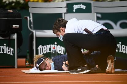 La alemana Laura Siegemund es tratada por el personal médico durante su partido de cuartos de final de tenis femenino contra la checa Petra Kvitova en el día 11 del torneo de tenis Roland Garros 2020, en París.