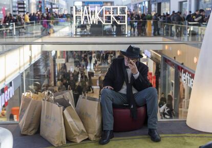 Un hombre descansa en un día de compras en el centro comercial Intu Puerto Venecia, en Zaragoza.