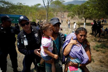 Uma família de migrantes da América Central é detida por policiais federais do México durante uma batida policial que abordou e prendeu centenas de pessoas que caminhavam com destino aos EUA, em Pijijiapan, em 22 de abril. 