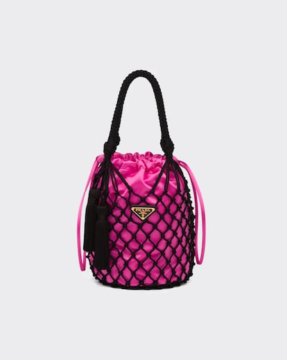 Prada. Bautizado como Fishnet Bag, se postula como uno de los bolsos más deseados de la temporada. Su propio nombre elude a la red de pesca que envuelve esta delicada bombonera a modo de macramé, junto a un saco en rosa Barbie y el logo en la delantera.