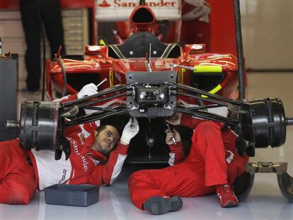 Mecnicos de Ferrari trabajan en el coche de Fernando Alonso.