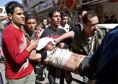 Jóvenes palestinos trasladan a uno de los heridos durante una protesta contra los soldados, esta mañana en Ramala.