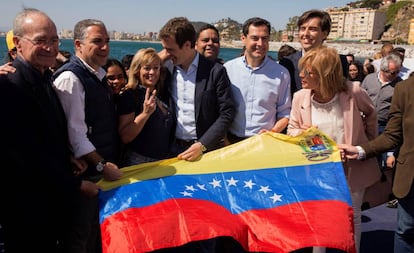 El presidente del PP, Pablo Casado, posa en Málaga, junto a representantes del PP andaluz, con una bandera venezolana. 