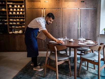 Un camarero monta una mesa en un restaurante de Madrid.