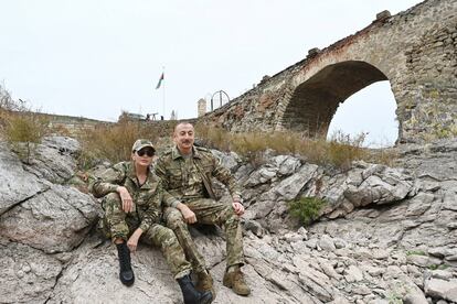 El presidente de Azerbaiyán, Ilham Aliyev, y su mujer, Mehriban Aliyeva, posan en traje de campaña junto al antiguo puente de Jodaafarin, en los territorios recuperados tras la reciente guerra contra Armenia.