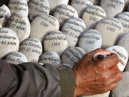 Un hombre escribe en un memorial a las víctimas en Perú.