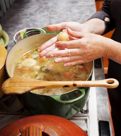 'Sopa de pollo para el alma' es el título de un célebre libro de autoayuda de Jack Canfield y Mark V. Hansen, y no es de extrañar que sus autores lo hayan llamado así, pues el caldo de pollo tiene algo reconstituyente, y más si se le añaden verduras y unas bolas jugosas de harina de 'matzá' o pan ácimo, enriquecidas con huevo y grasa de pollo y sazonadas con pimienta negra que lo convierten en una de las recetas favoritas de la tradición gastronómica judía askenazí: la sopa de bolas de 'matzá'. En este plato, típico de la festividad de Pésaj, las jugosas bolas pueden optar por flotar o por hundirse, pero ambas opciones son igual de sabrosas. En los 'delis' judíos estadounidenses la Matzo Ball Soup es una de las más populares y quien viaje a <a href="https://elviajero.elpais.com/tag/nueva_york/a" target="_blank">Nueva York</a> puede probarla —o, en estos tiempos, pedirla para llevar— en <a href="https://www.russanddaughterscafe.com/" target="_blank">el Russ & Daughters Cafe</a>, el restaurante que abrió la familia Russ en 2014 para celebrar el centenario de su tienda de comestibles de tradición judía. En la foto, preparación de la sopa de bolas de 'matzá'.