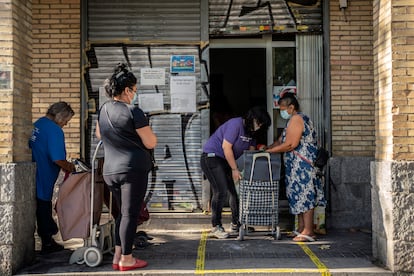 Un grupo de personas en el banco de alimentos Gran Avenida 24, en el barrio de Orcasitas (Madrid).