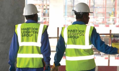 Dos trabajadores con chalecos con el logo de la empresa HLG