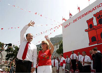 Peter Caruana, con su esposa, saluda al público durante la celebración del National Day en el Peñón.