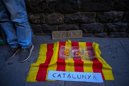 Un activista independentista catalán al lado de la calle Bisbe en el distrito histórico, mostrando una bandera y un cartel que dice ''Independencia'' en Barcelona el 10 de noviembre de 2024