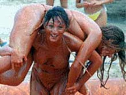 Dos jóvenes se bañan en la piscina de fango de Gandía.