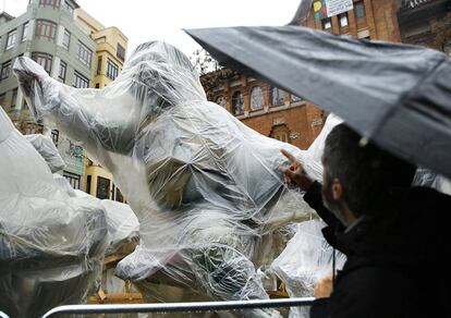 Los ninots' desplegados en las calles de Valencia, enfundados en plástico para protegerlos de la lluvia.
