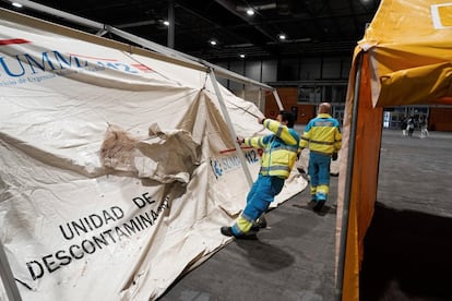 Trabajadores levantan una unidad de descontaminación en uno de los pabellones del recinto ferial Ifema, en Madrid.